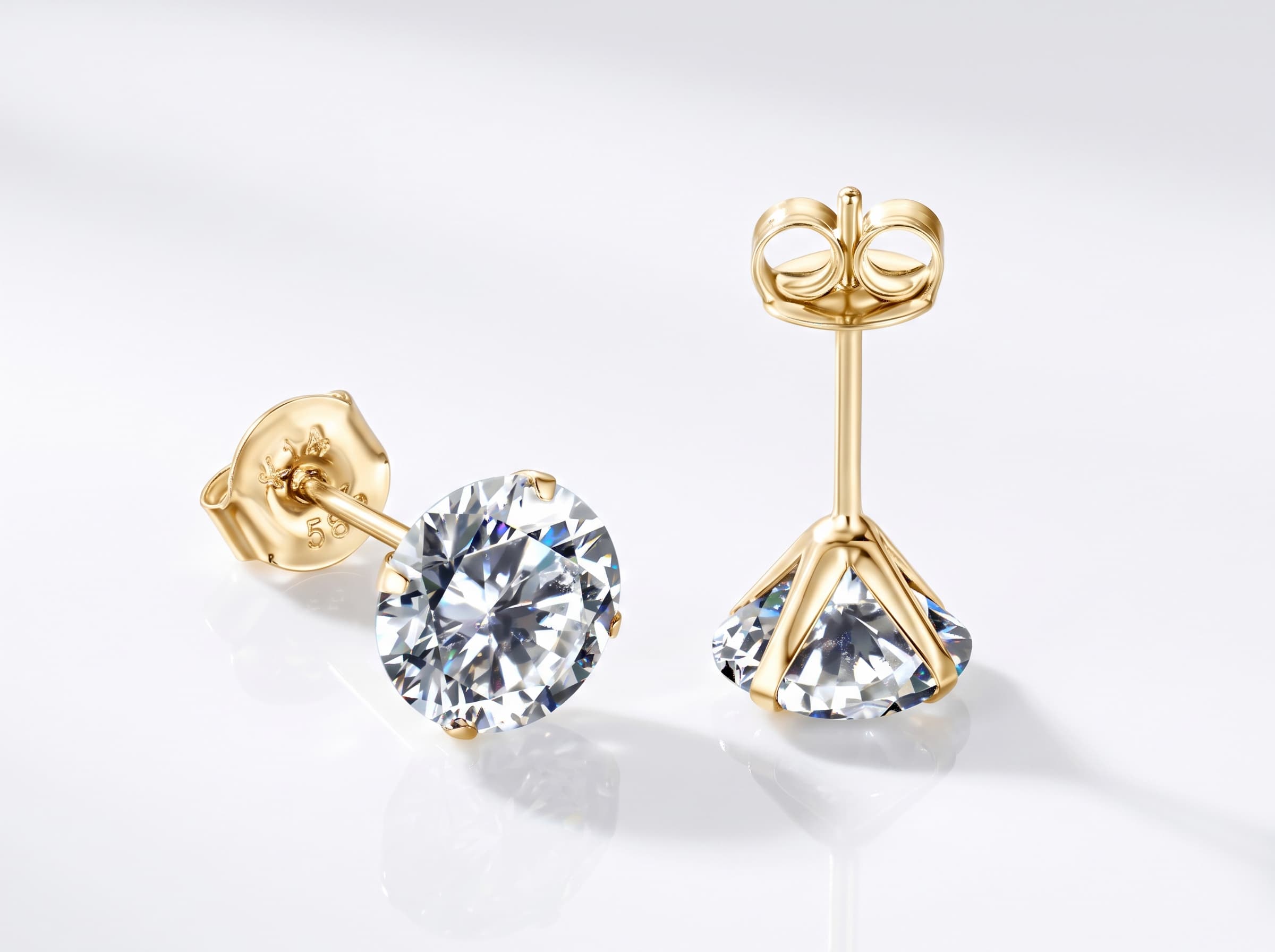 Pair of solid 14K gold stud earrings with 0.5 carat round brilliant moissanite stones (1.0 CTW) displayed in an emerald green velvet box beside a JEWELRY KOVAL card
